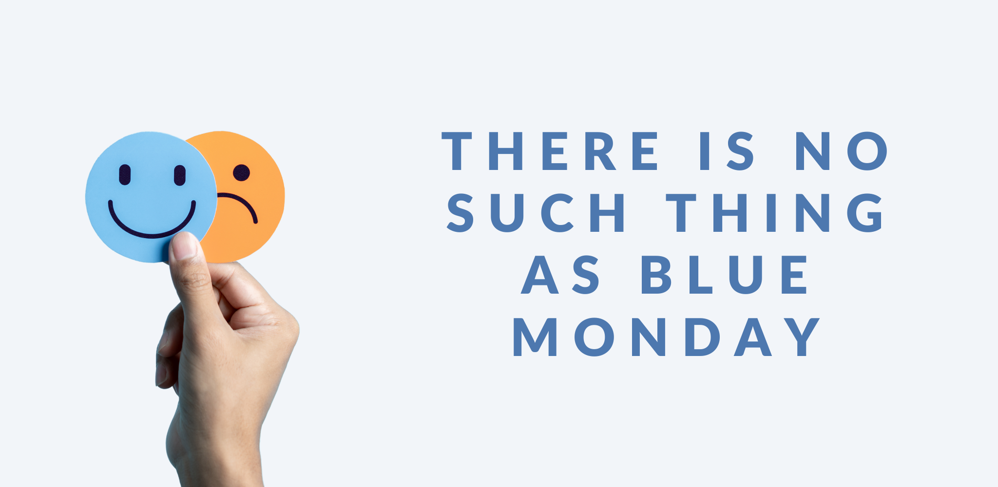 Simple graphic for a blog post titled 'THERE IS NO SUCH THING AS BLUE MONDAY' in bold blue uppercase letters on a light blue background. To the left is a hand holding two circles - one is blue with a smiling face, the other is orange and slightly behind with a sad face.